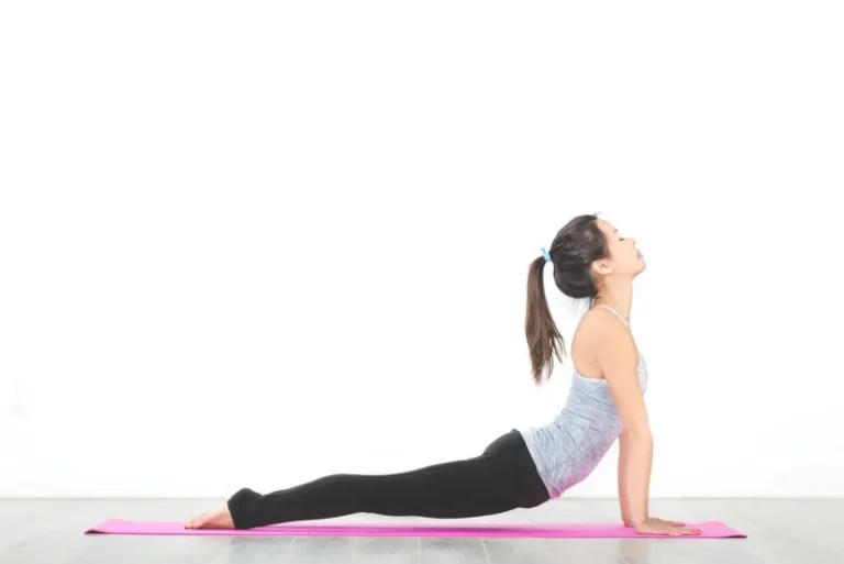 Žena na joga prostirci u meditativnom položaju sa rukama na kolenima, fokusirana na disanje