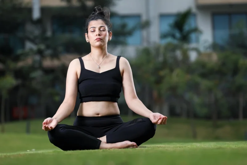 Žena u pozi meditacije, fokusirana na disanje i opuštanje